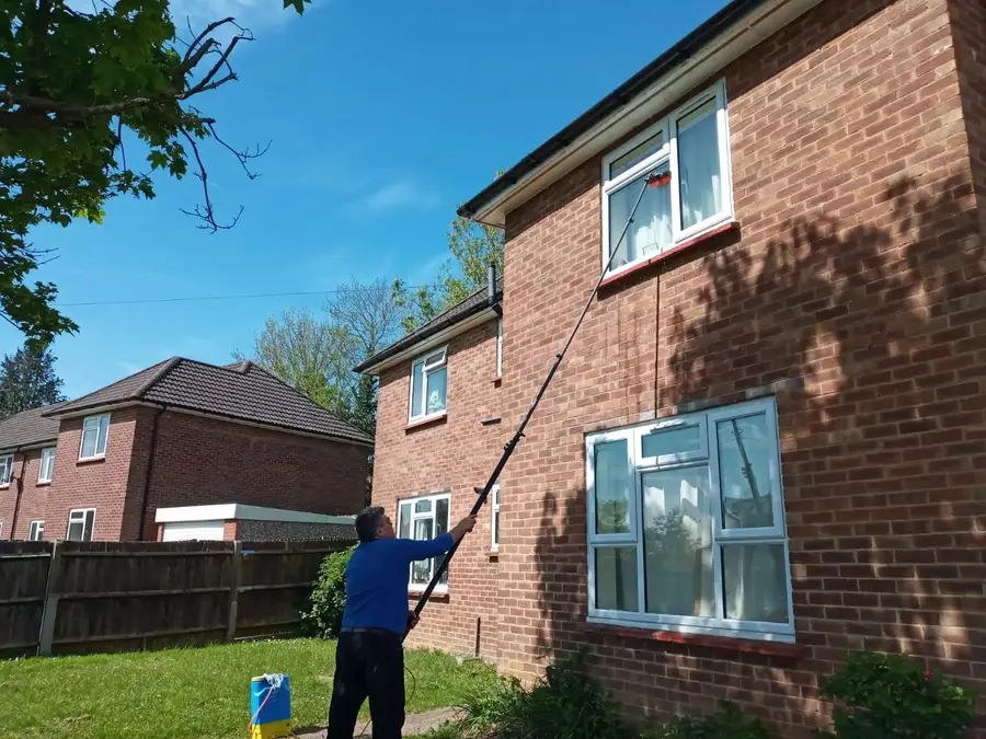 Cleaning second-storey windows on a brick semi in Ickenham