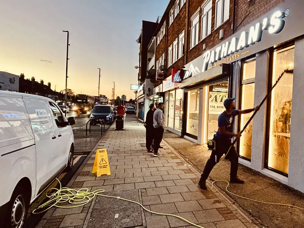 Shop front window cleaning in Uxbridge in the early morning