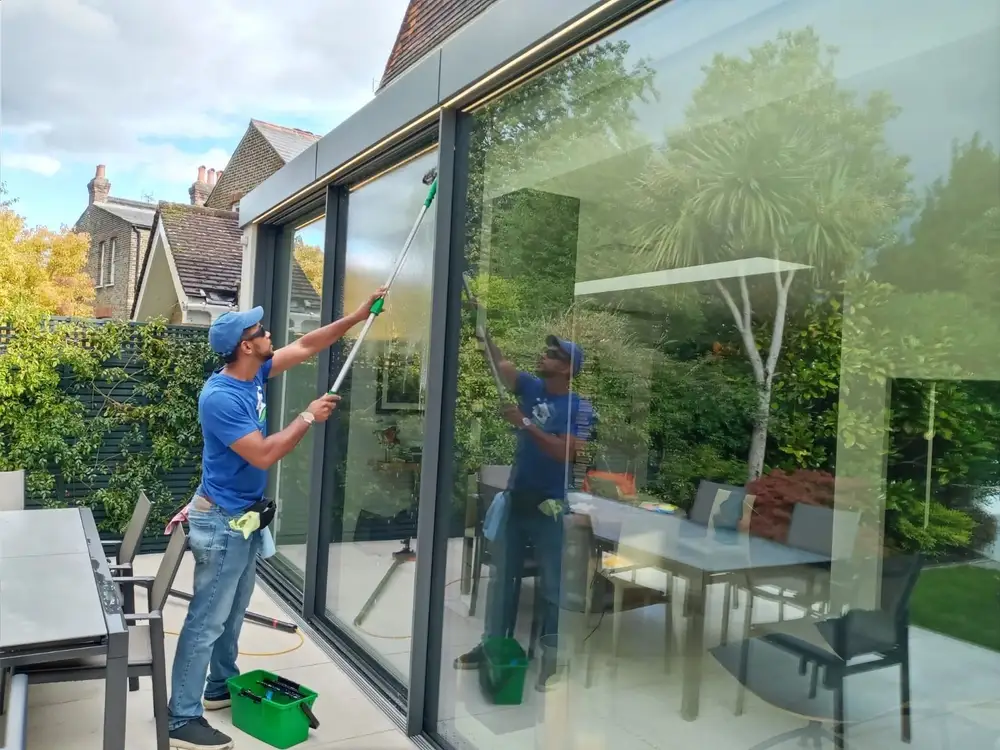 Cleaning floor-to-ceiling glass doors on a garden extension